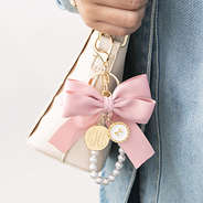 pink monogrammed bag charm keychain on white bag