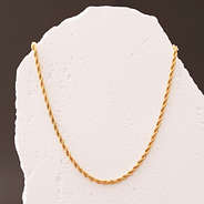 close up gold twisted rope necklace with brown background