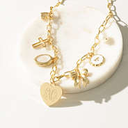 gold charm necklace on marble dish