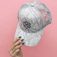 girl holding up hat on pink