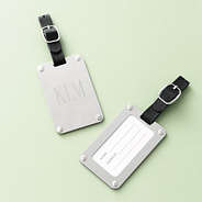 silver stainless steel luggage tag on green background