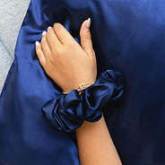 navy silk scrunchie and pillowcase on wrist