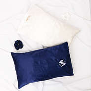 white and navy satin pillowcases and scrunchies on sheets