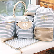 monogrammed gray striped travel bags on bench