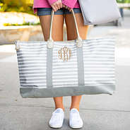 gray striped travel bag with white monogrammed sneakers