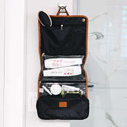 hanging toiletry bag with multiple pockets beside shower