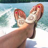 girl wearing monogrammed sandals on boat at the lake