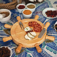 Personalized Mariner's Cheese Board on a table cloth with  variety of cheeses and meats