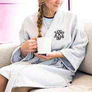 model wearing gray monogrammed robe holding coffee mug