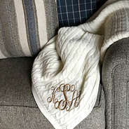 ivory cable knit monogrammed throw on sofa with pillows