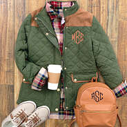 olive monogrammed quilted barn coat with plaid layering tunic, sneakers and mini backpack