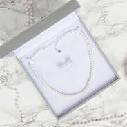 open box with set of pearl earrings and necklace on marble background