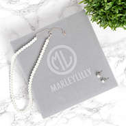 closed box with pearl earrings and necklace set on marble