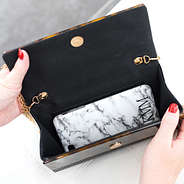 cell phone inside of monogrammed tortoise clutch