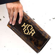 close up of monogrammed tortoise clutch