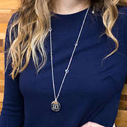 silver monogrammed necklace with blue shirt