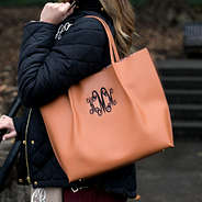 monogrammed brown tote on shoulder