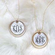 monogrammed pearl disc necklaces on white fur rug
