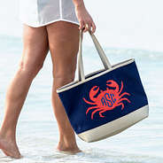 girl holding monogrammed crab beach bag walking in the ocean