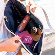 inside pineapple beach tote with monogrammed sandals and hat and sunscreen