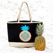 monogrammed sparkly pineapple beach tote sitting in the sand