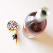 monogrammed confetti wine stopper beside open wine bottle
