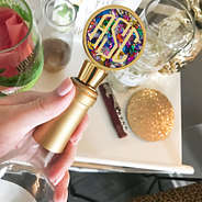 confetti gold wine stopper in wine bottle near bar cart
