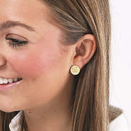 gold monogrammed disc earrings on brunette