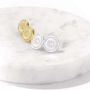 gold and silver earrings on marble dish