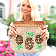 holding monogrammed pineapple wooden handle clutch