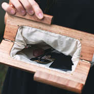inside wooden handle clutch with phone and sunglasses