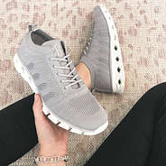 light gray athleisure sneakers in hand