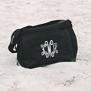 monogrammed black can cooler sitting in sand at beach