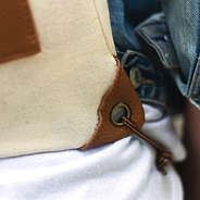 grommet detail shot on monogrammed casual cinch bag