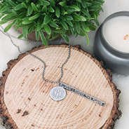 silver monogrammed jeremiah 29:11 necklace on wood plank