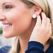 girl wearing sterling silver monogrammed nala earrings