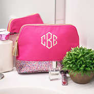 monogrammed hot pink and confetti cosmetic case sitting on bathroom counter
