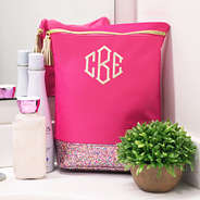 monogrammed ditty bag in hot pink with confetti bottom sitting on bathroom counter