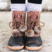 brown monogrammed duck boots with faux fur pom poms on laces