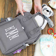 filling monogrammed gray diaper bag with stuffed animal panda