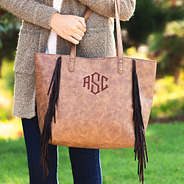 holding monogrammed fringe tote bag
