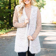 tan striped two way tunic with scoop neck in front layered with cozy knit vest