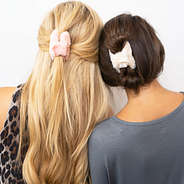 pink and white fuzzy hair clips in blonde and brunette hair