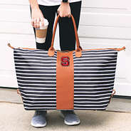 woman holding nc state striped weekender bag