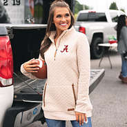 brunette at tailgate wearing alabama quilted pullover while holding football at tailgate