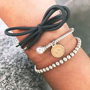 charcoal gray bow hair tie on wrist with bracelets