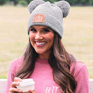 grey monogrammed pom pom beanie on brunette