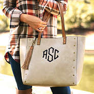 taupe monogrammed cheyenne tote on arm with tassel