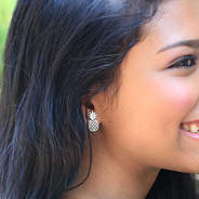 silver pineapple earrings in ears