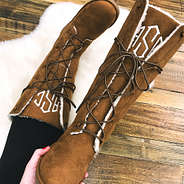 holding monogrammed lace up sherpa boots